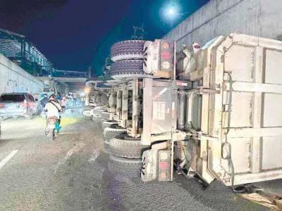 一辆22轮大型运沙自卸卡车10月14日凌晨在奎松市Batasan隧道中...